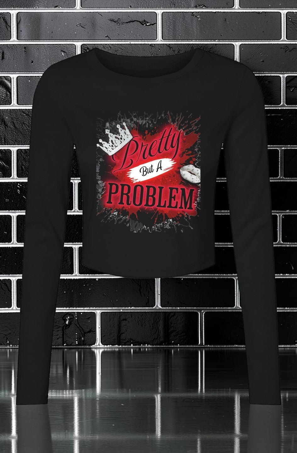 CocoMe Couture black long sleeve micro rib baby tee with a Pretty but a Problem graphic print on a brick background.