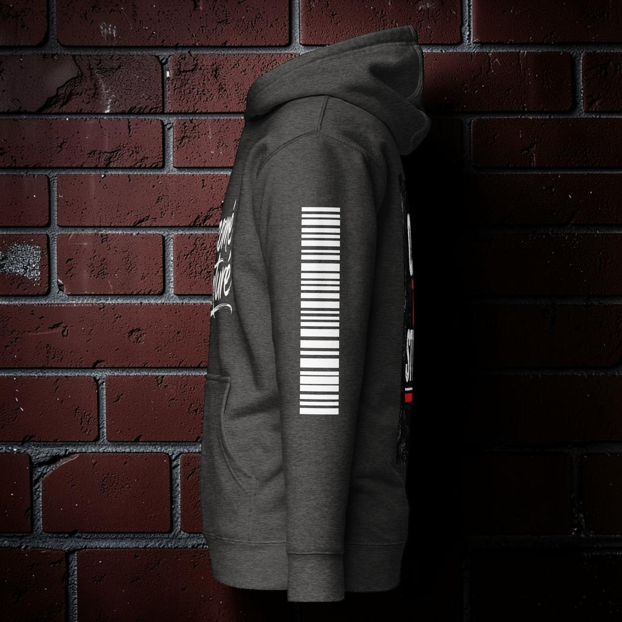 CocoMe Couture charcoal heather premium hoodie with white sleeve graphic against a brick wall background