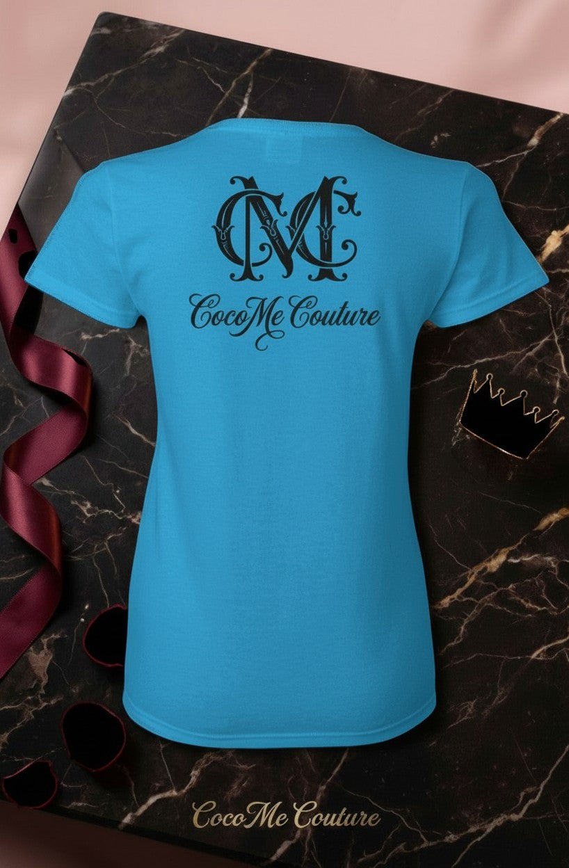 CocoMe Couture sapphire blue heavy cotton women's tee with black logo graphic on back, displayed on marble surface.