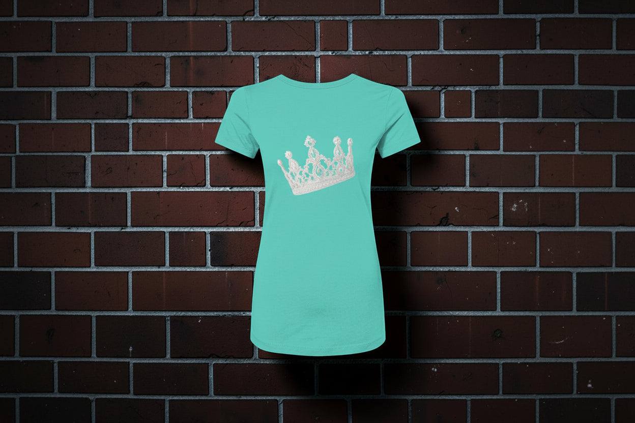 CocoMe Couture teal slim-fit women's graphic tee featuring a white crown design on a brick wall background