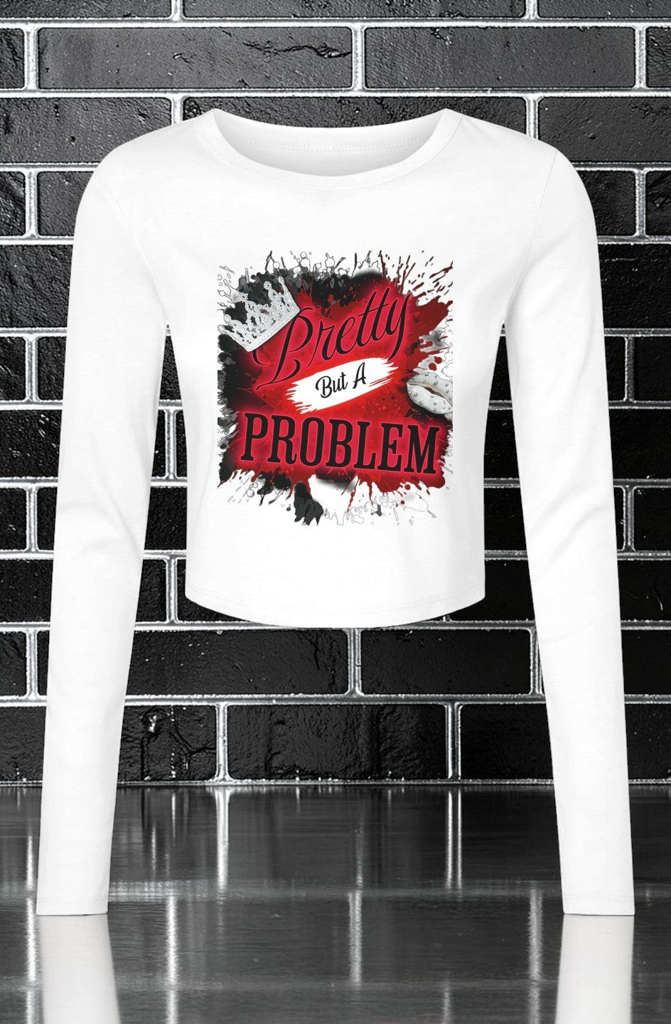 CocoMe Couture white long sleeve micro rib baby tee with Pretty but a Problem graphic print on a brick background.